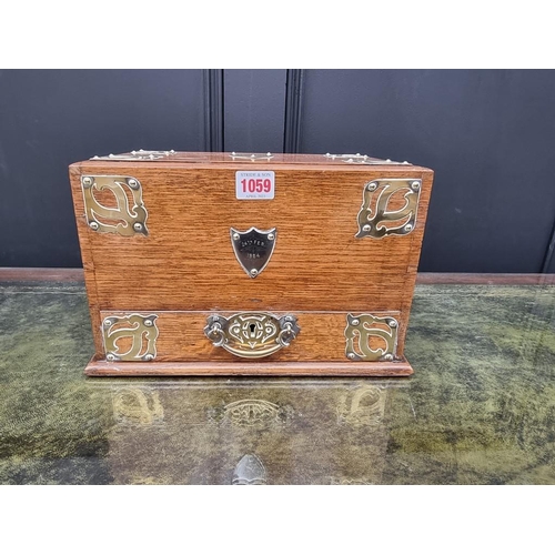 1059 - A Victorian oak and brass mounted stationary casket, 31cm wide. 