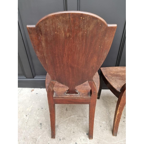 1075 - An interesting set of three George III shield back hall chairs, each with painted lion crest to back... 