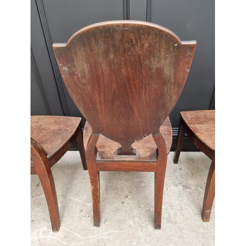 1075 - An interesting set of three George III shield back hall chairs, each with painted lion crest to back... 