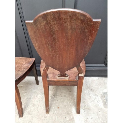 1075 - An interesting set of three George III shield back hall chairs, each with painted lion crest to back... 