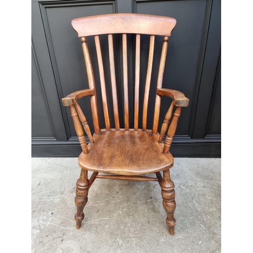 1077 - A Victorian ash, elm and beech lath back elbow chair. 