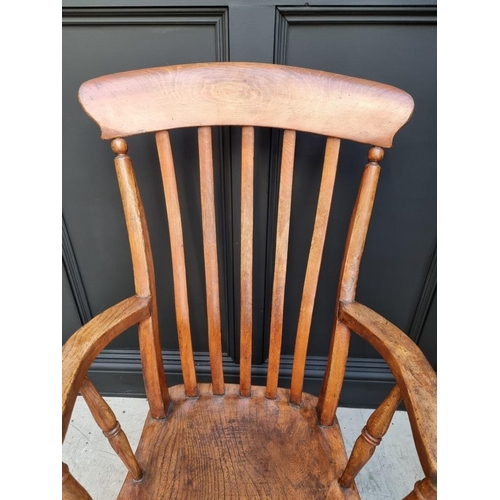 1077 - A Victorian ash, elm and beech lath back elbow chair. 