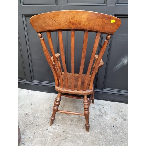 1077 - A Victorian ash, elm and beech lath back elbow chair. 