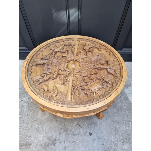 1091 - An Eastern carved hardwood circular low occasional table, 91cm diameter.