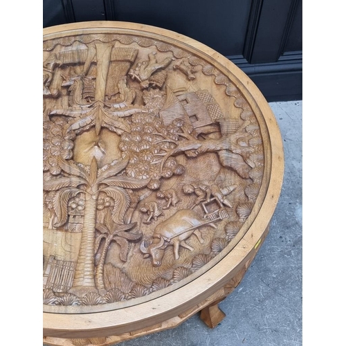 1091 - An Eastern carved hardwood circular low occasional table, 91cm diameter.