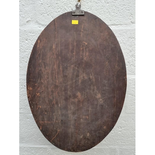 1107 - An Irish style oval wall mirror, 60.5 x 42.5cm.  