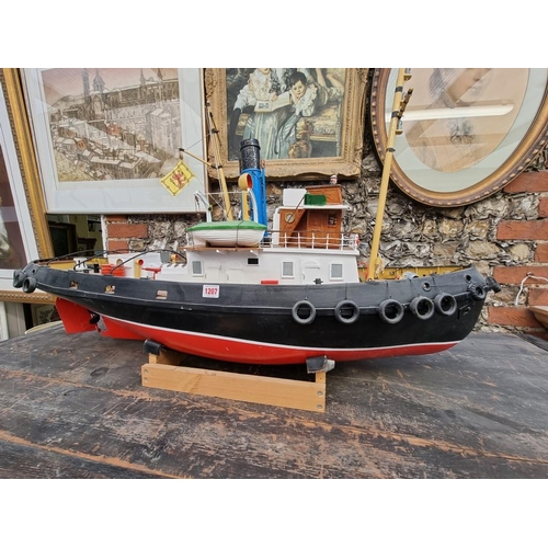 1207 - A large painted model tug, 113cm long, on pine stand.