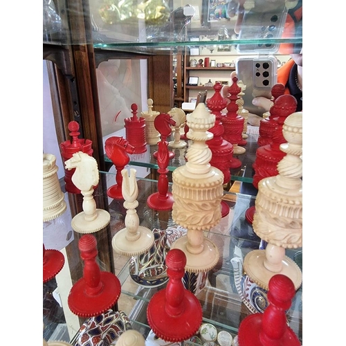 1306 - An antique bone chess set, red stained and natural, king 10.4cm, pawn 4.1cm.