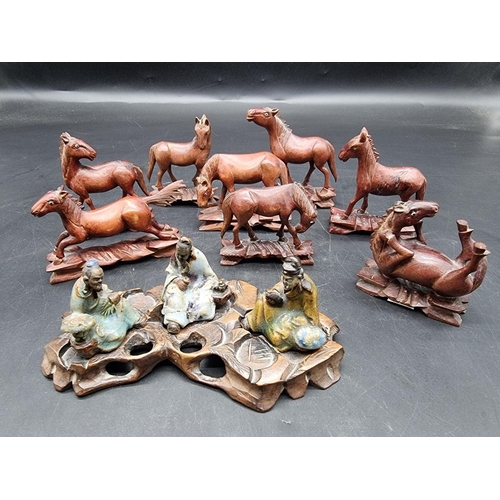 1317 - A set of eight carved wood horses of Mu Wang, each with inset eyes, largest 10.5cm wide; together wi... 