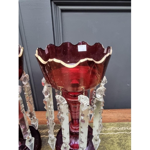 1384 - A pair of antique ruby glass lustres, 32cm high. 