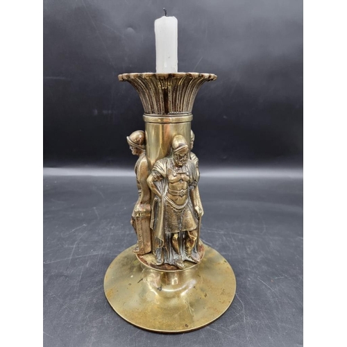 1454 - A brass candlestick, moulded with three Roman centurions, 25cm high.