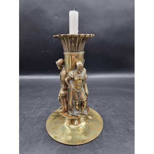 1454 - A brass candlestick, moulded with three Roman centurions, 25cm high.