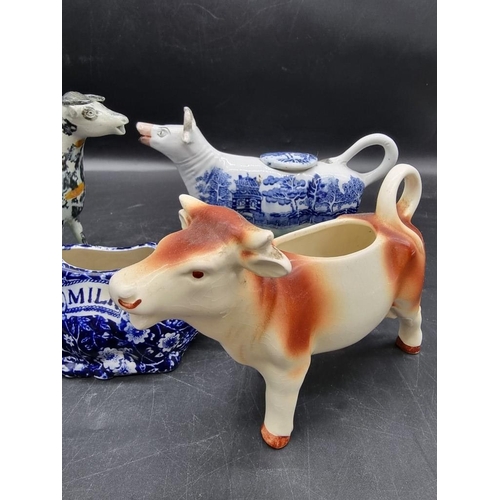 1474 - Five pottery cow creamers, to include an interesting 19th century Prattware example with milkmaid, 1... 