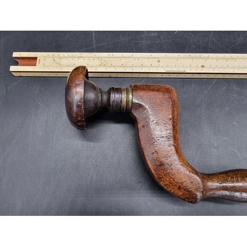 1573 - An antique brass mounted carpenters brace; together with a vintage slide rule.