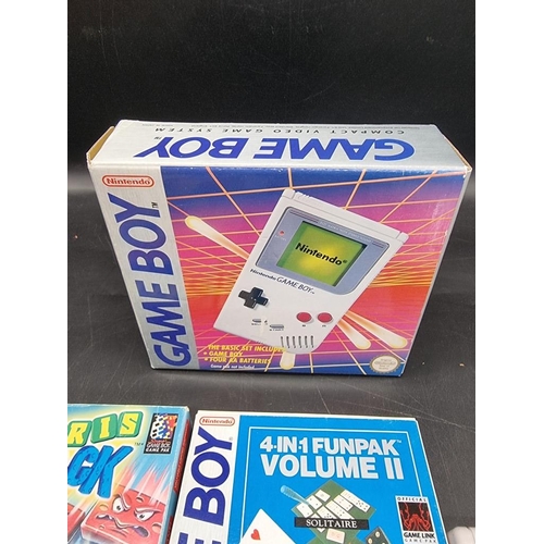 1587 - Two Nintendo Game Boys, one boxed; together with four related games.