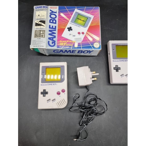 1587 - Two Nintendo Game Boys, one boxed; together with four related games.