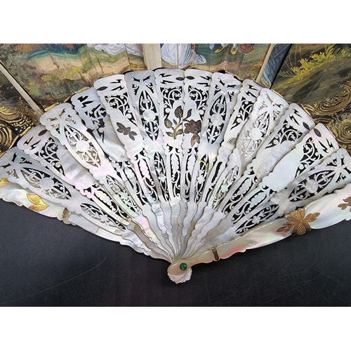 1650 - A 19th century mother of pearl and gouache fan, with finely pierced and gilt decoration, painte... 