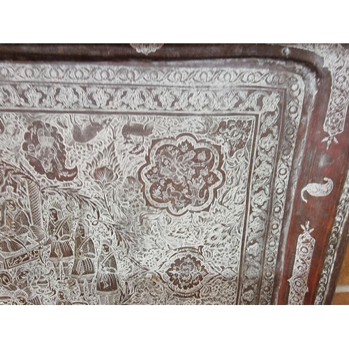 1712 - A large Persian or Indian copper rectangular tray, engraved with stylized figures and with a line of... 