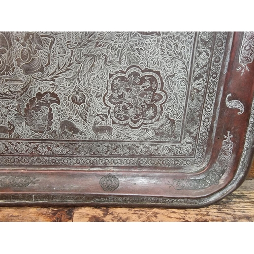 1712 - A large Persian or Indian copper rectangular tray, engraved with stylized figures and with a line of... 