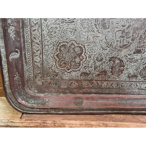 1712 - A large Persian or Indian copper rectangular tray, engraved with stylized figures and with a line of... 