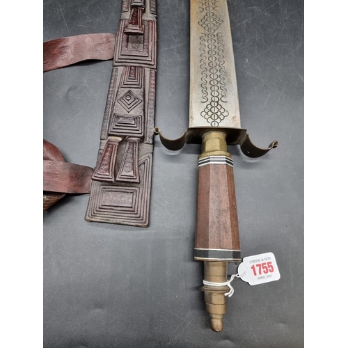 1755 - Ethnographica: an African sword and embossed leather scabbard, probably Nigerian, with 55cm blade.... 