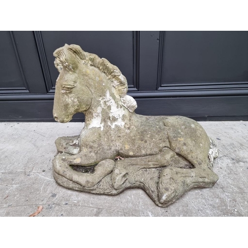 1782 - A composition stone recumbent horse, 62cm wide.