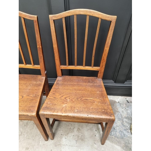 1823 - A pair of early 19th century elm dining chairs; together with another elm elbow chair; and another r... 