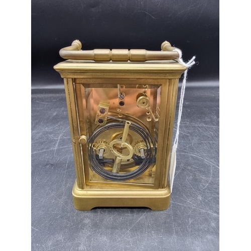 1545 - An antique brass carriage clock, with push button repeat and gong strike, height including handle 18... 