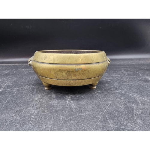 1552 - A Chinese bronze twin handled tripod censor, Qing, 15.5cm wide, 724g.   