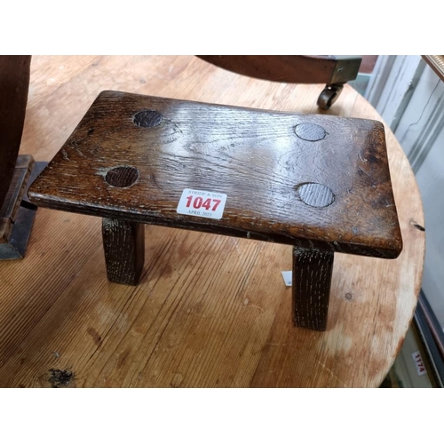 1047 - An old oak milking stool, the base stamped 1942, 25.5cm wide.