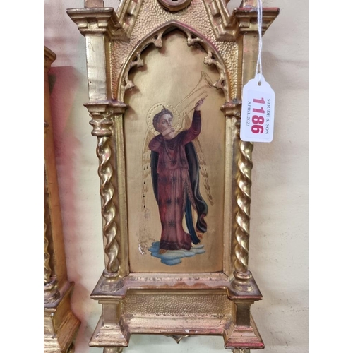 1186 - A pair of carved gilt wood tabernacle framed paintings of saints, 45 x 14cm. (2)