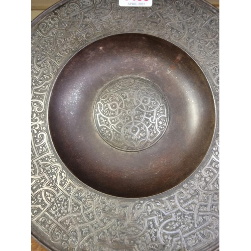 1498 - An unusual 19th century Islamic style iron or steel dish, with stylized decoration, 24.5cm diameter.... 