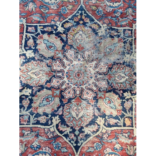 1005 - A Persian carpet, having central floral medallions, with floral cartouches to each corner of ce... 