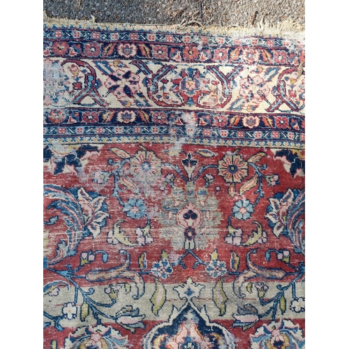 1005 - A Persian carpet, having central floral medallions, with floral cartouches to each corner of ce... 