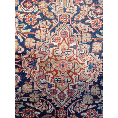 1012 - A Persian rug, having central floral medallion, with floral decoration to each corner, 199 x 131cm.... 