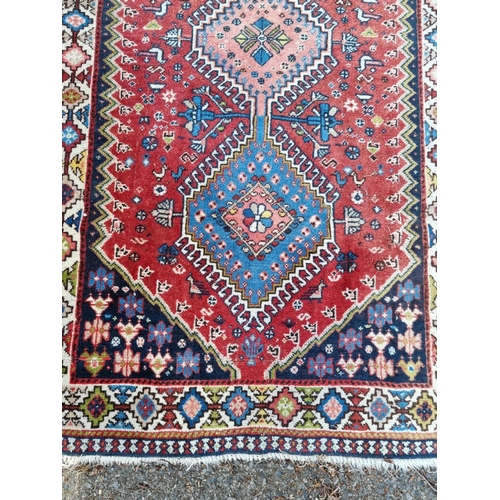 1013 - A small Persian rug, having three central medallions, with floral and geometric borders, 142 x 81cm.... 
