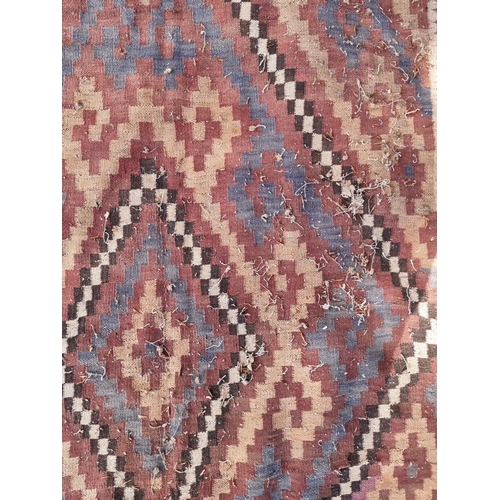 1014 - An Afghan Kelim rug, having two geometric medallions, 407cm x 165cm.