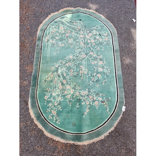 1018 - An antique Chinese oval rug, 220 x 136cm. 