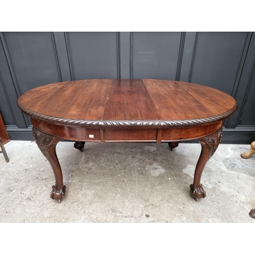 1037 - A late 19th/early 20th century carved mahogany extending dining table, 152cm extended, with winding ... 