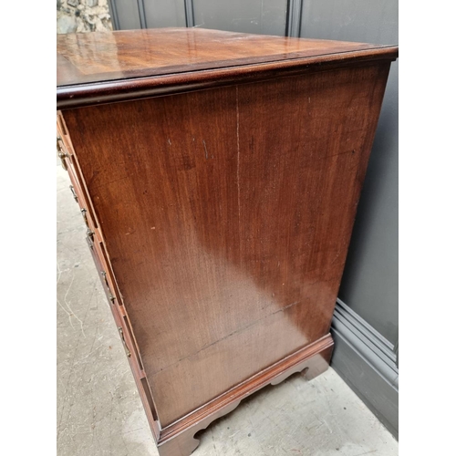 1059 - A small George III mahogany and crossbanded four drawer chest, with brushing slide, 87cm wide.... 