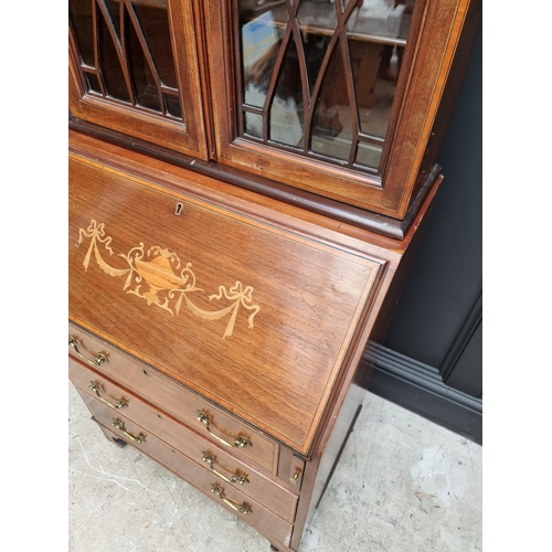 1062 - A small Edwardian mahogany and inlaid bureau bookcase, 66.5cm wide.