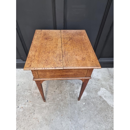 1064 - An unusual early 20th century oak writing table, by Asprey, the hinged top revealing a rising leathe... 