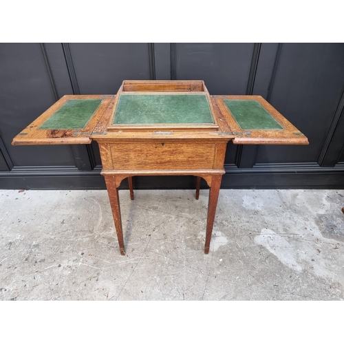 1064 - An unusual early 20th century oak writing table, by Asprey, the hinged top revealing a rising leathe... 