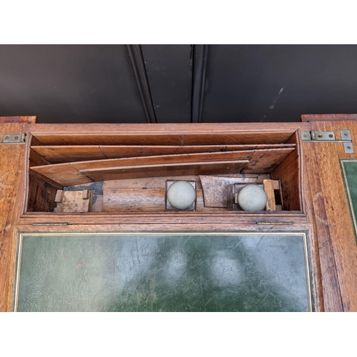 1064 - An unusual early 20th century oak writing table, by Asprey, the hinged top revealing a rising leathe... 