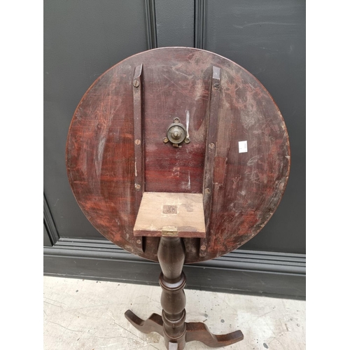 1069 - An early 19th century mahogany and oak circular tilt top tripod table, 48cm diameter. ... 