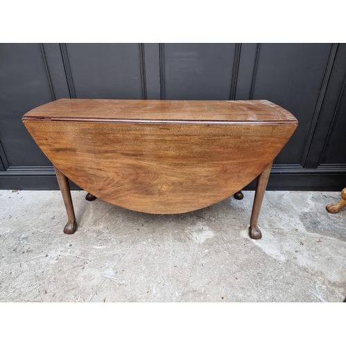 1070 - A George III mahogany drop leaf table, with ball and claw feet, 132cm wide. 