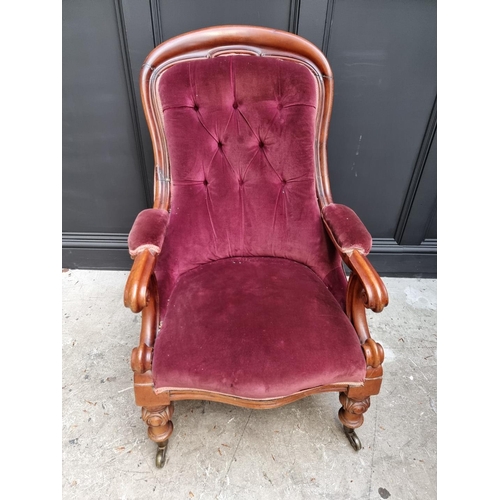 1075 - A Victorian mahogany and button upholstered open arm occasional chair. 