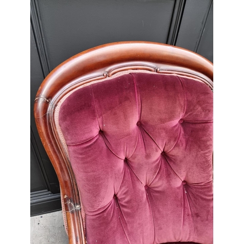 1075 - A Victorian mahogany and button upholstered open arm occasional chair. 