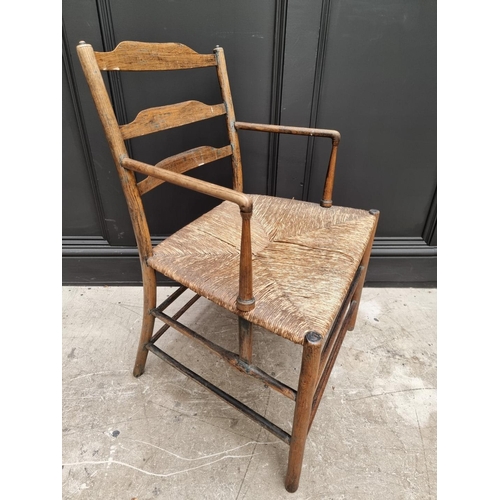 1083 - An antique ash and rush seated Sussex style elbow chair, with ladder back.