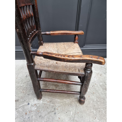 1084 - An unusually small 19th century ash and rush spindle back armchair.